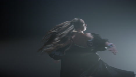 young man holding woman during dance on stage. ballroom dancers spinning indoors