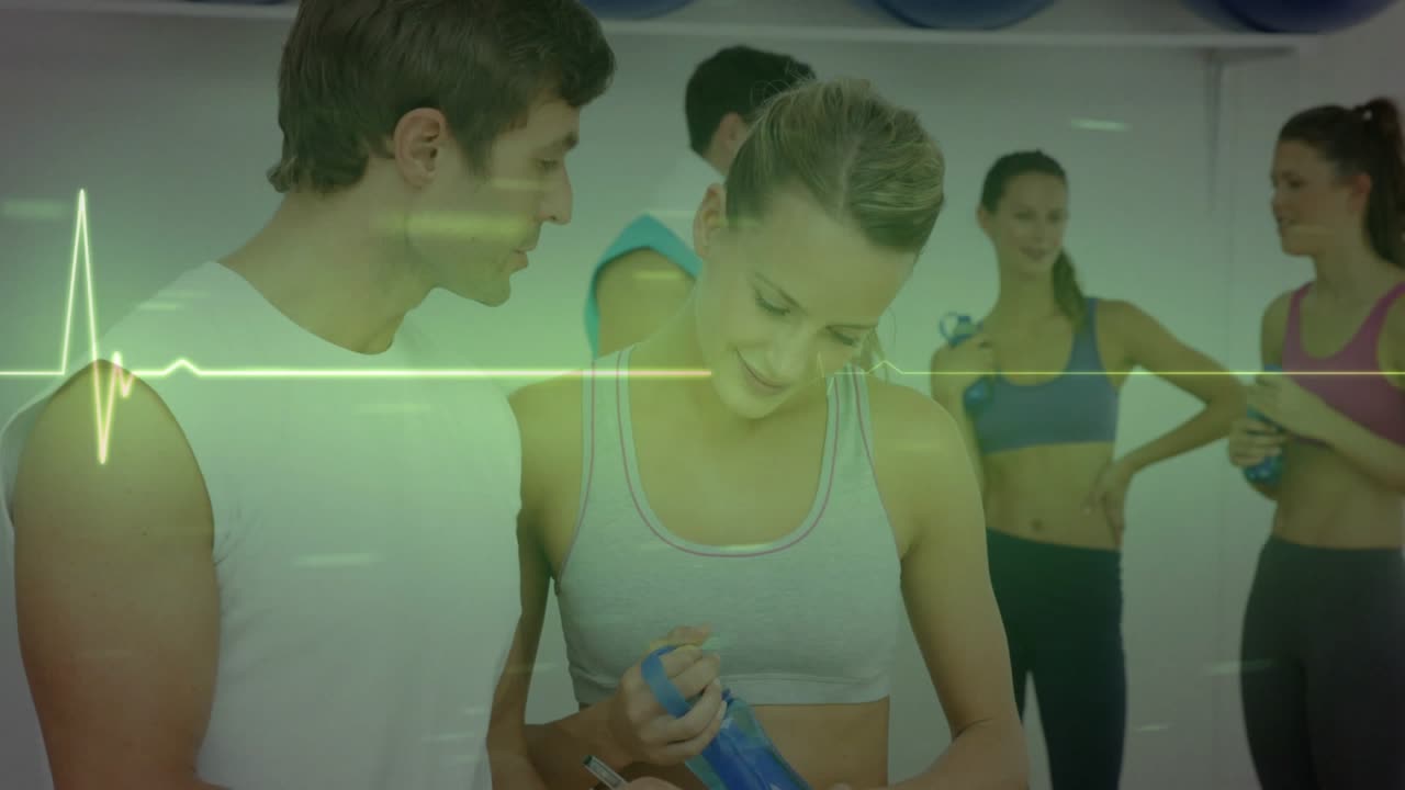 Gym trainer tapping clipboard guiding woman checking bottle for pulse while ECG pulsing over pair