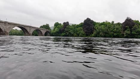 river flowing under a historic stone bridge