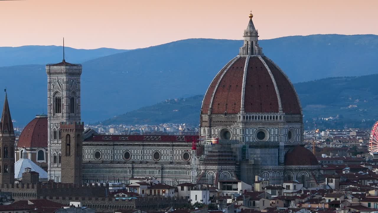 피렌체의 산타 마리아 델 피오레 대성당은 미란젤로 광장에서 볼 수 있으며, 왼쪽 배경에는 조명된 페리스 이 있습니다.