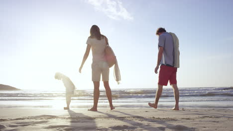 Familia-Feliz-Jugando-En-La-Playa-Al-Atardecer-De-Vacaciones