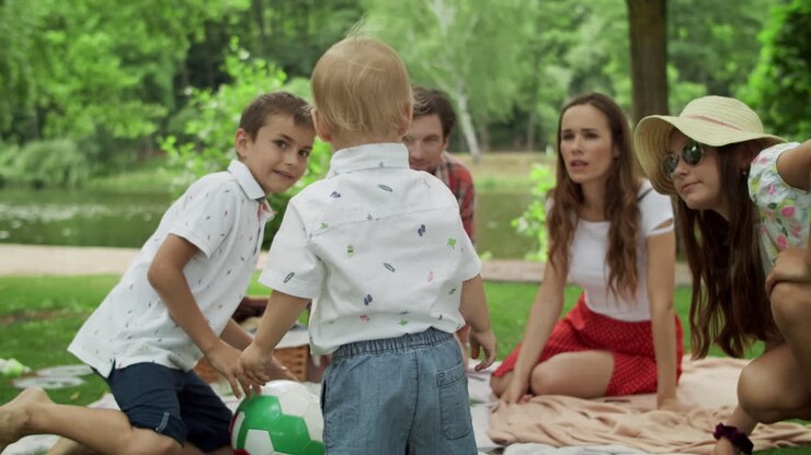 fratelli felici che giocano insieme nella foresta. famiglia sorridente che fa un picnic all'aperto