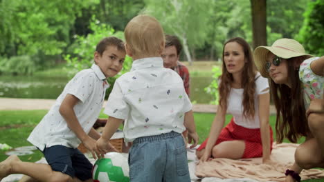 happy siblings playing together in forest. smiling family having picnic outdoors