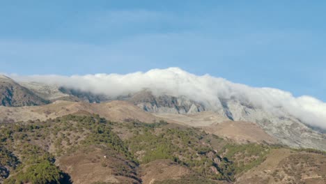 lapso de tiempo de nubes ondulantes rodando sobre la cima de una montaña