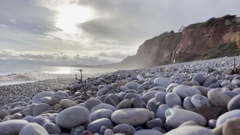 Low-wide-shot-across-a-pebble-beach-in-the-south-of-England,-with-lovely-evening-daylight