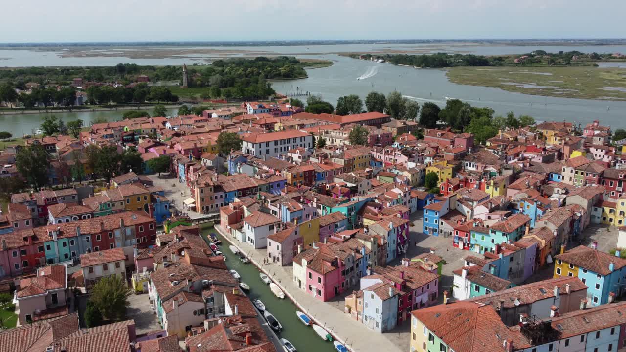 Splendide riprese aeree di Burano, Italia, con isole sullo sfondo e molte case colorate, canali e barche.