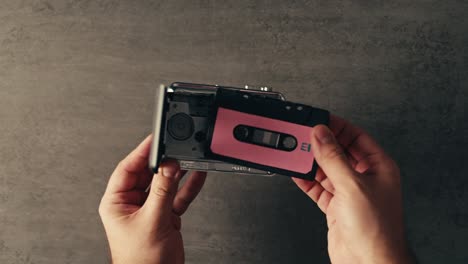 hands opening a cassette tape player