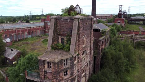 abandoned old overgrown coal mine industrial rusting pit wheel ruin aerial view rising