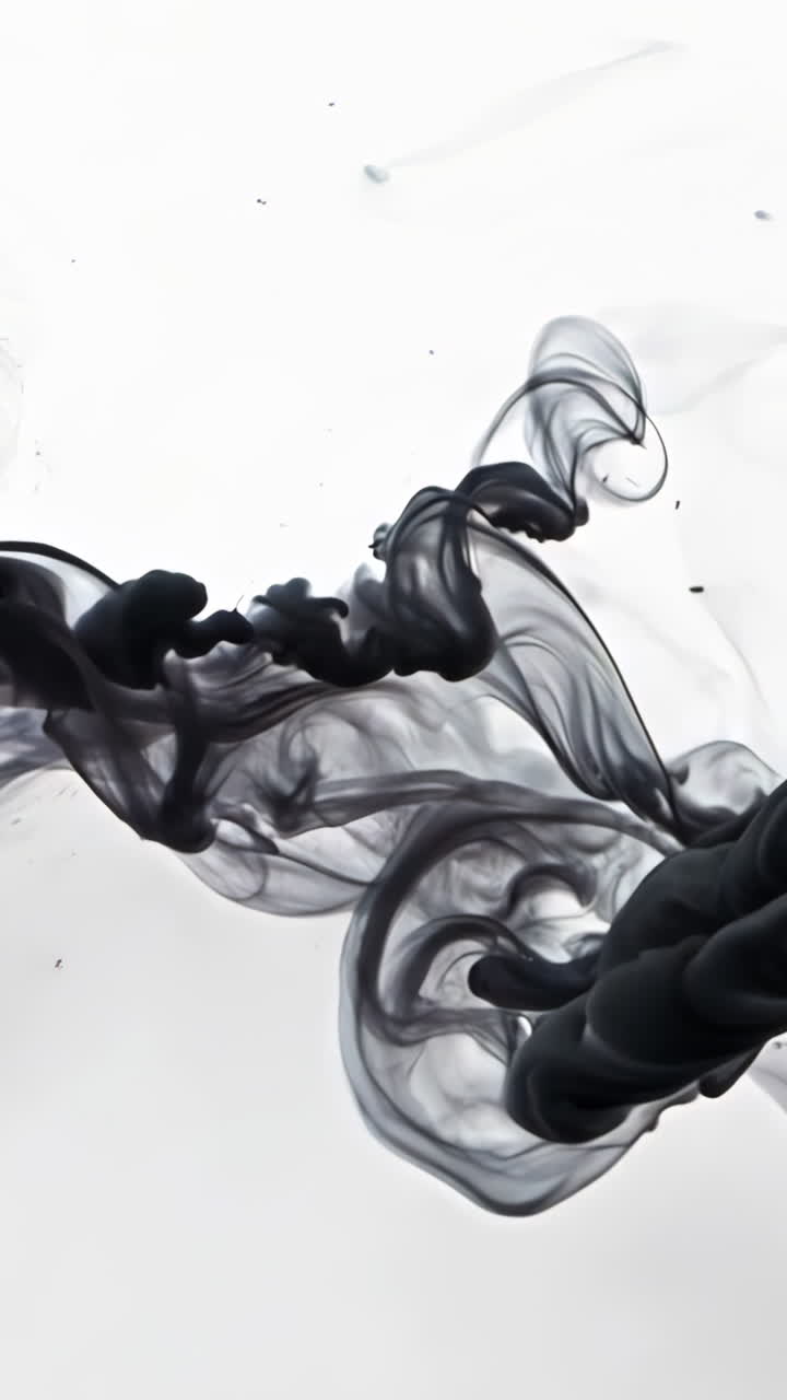 A long, curving line of smoke is shown in black and white. The smoke is thick and dark, and it seems to be coming from a source in the distance. The image has a moody, mysterious feel to it