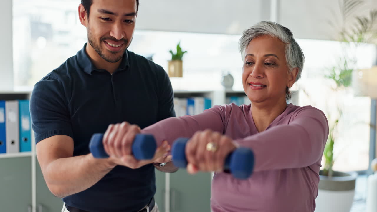 fisioterapeuta que asiste a un paciente anciano con ejercicios con pesas