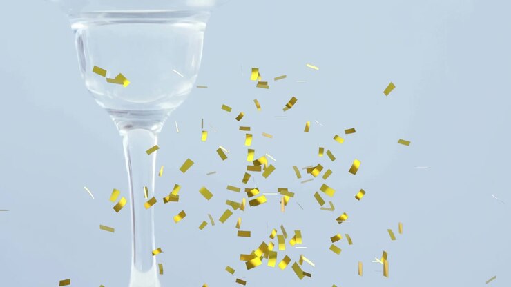 Animation of confetti falling over olives in wine glass on white background