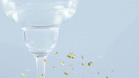 Animation-of-confetti-falling-over-olives-in-wine-glass-on-white-background