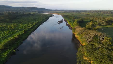 drone flying over a river towards the horizon