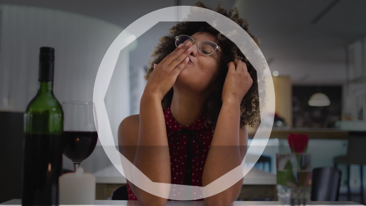 animación del círculo sobre una feliz mujer biracial con vino haciendo una videollamada