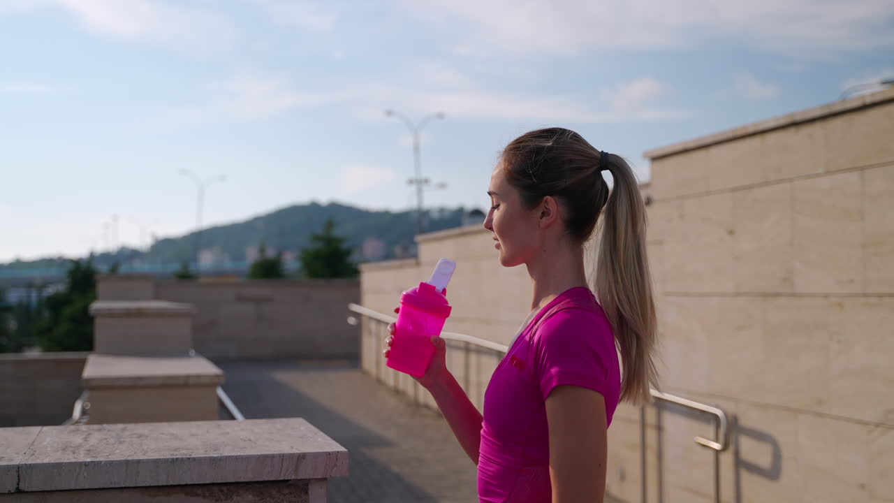 mujer bebiendo agua al aire libre