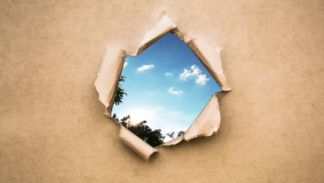 kreatives 4k-time-lapse-video von schnell bewegten wolken am blauen himmel, die durch ein kreisloch mit zerrissenen rändern in altem retro-grunge-vintage-papier sichtbar sind.
