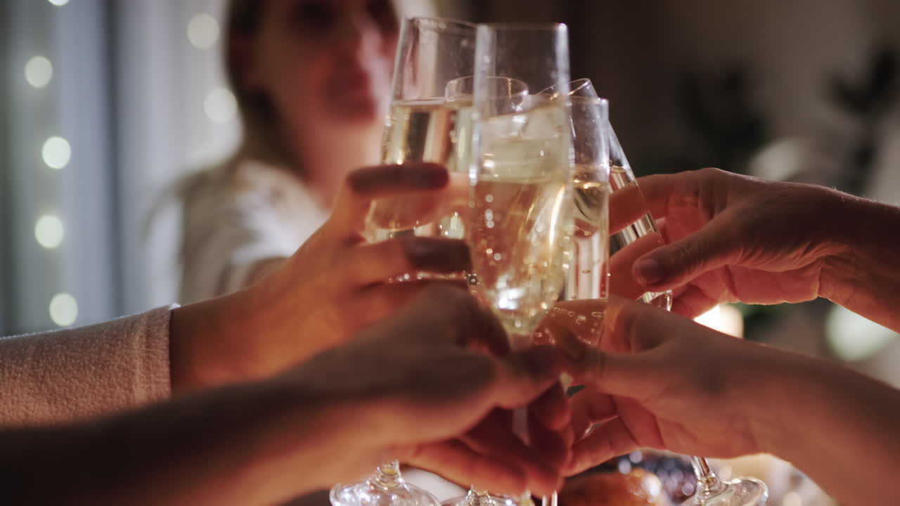 Happy friendly family clinks glasses of sparkling wine at the festive table. 4k video