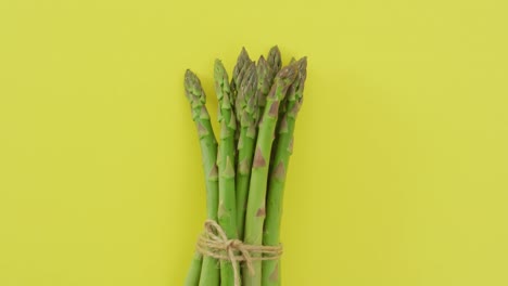 Video-of-bundle-of-fresh-asparagus-with-copy-space-over-green-background