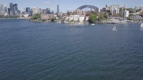 drone shot overlooking sydney harbour with opera house and harbour bridge