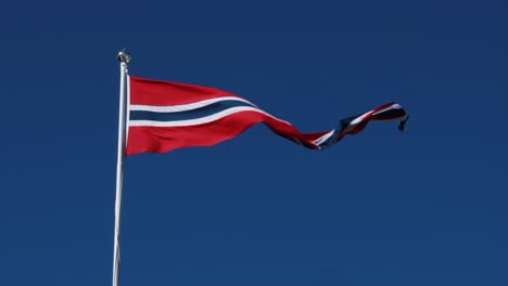 Norway-pennant-flag-waving-in-the-wind-against-deep-blue-sky.