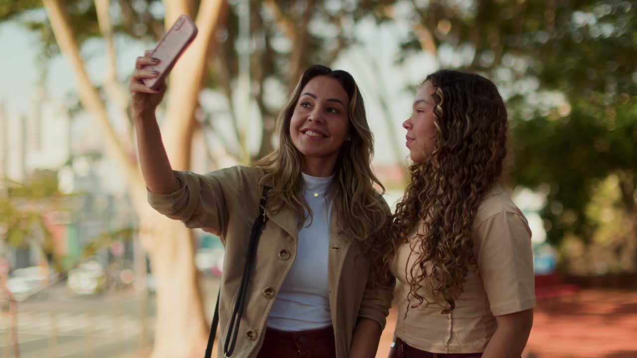 Dos mujeres tomando selfies al aire libre