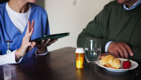 enfermera revisando la medicación con un paciente anciano