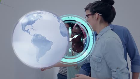 animation of globe and clock on scanner processing data over diverse colleagues at work