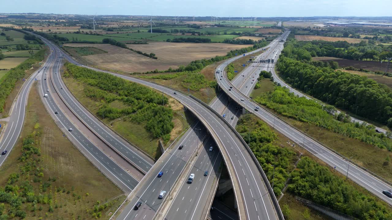 Top down drone aerial footage of motorway highway intersection with vehicles, traffic and transport Rugby England UK