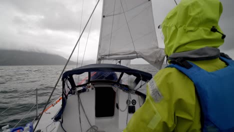 sailing by coast of alaska on rough sea under dramatic sky