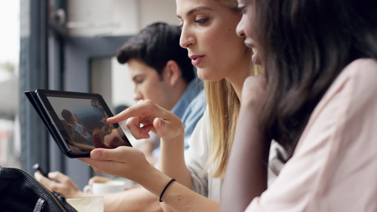 amigas jóvenes que usan una pantalla táctil de tableta digital que muestra fotografías de vacaciones