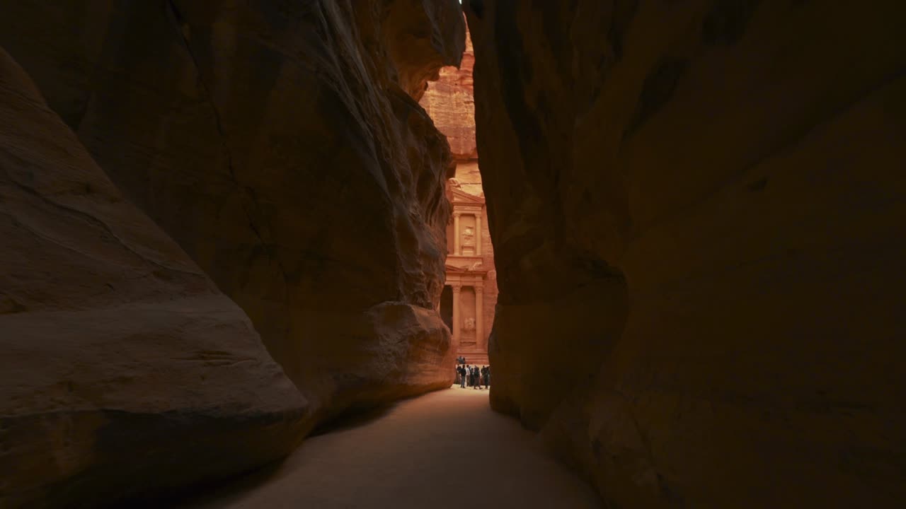 caminando hacia el tesoro a través de la siq en petra, sitio histórico del patrimonio de la unesco tallado en piedra arenisca en jordania. famoso indiana jones última cruzada lugar de filmación y destino turístico khaznet. disparo revelador.
