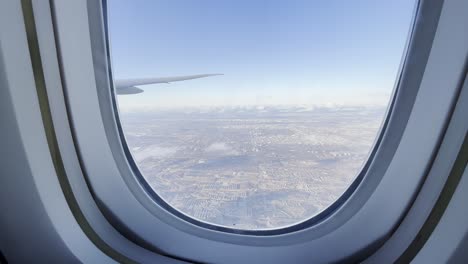 cabin window view of a aeroplane wing over an australian landscape during a plane flight.