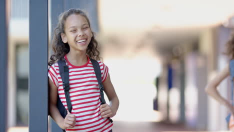 in school, smiling girl with backpack leaning against pillar, enjoying break, copy space
