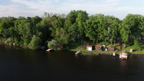 aerial wide shot of a person fishing off lake dock