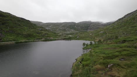 Drohne-Fliegt-Durch-Enges-Tal-über-See-Und-Wasserfall-In-Bodennähe-Auf-Senja