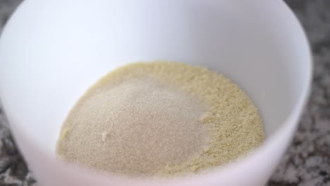 verter el ingrediente de azúcar de caña en un tazón de flor de almendra para hornear la receta de galletas