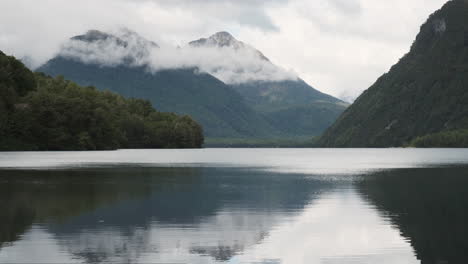 Montañas-Brumosas-Bellamente-Reflejadas-En-Un-Lago-Tranquilo