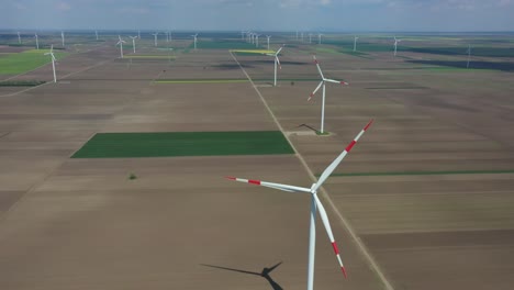 aerial view of several windmills, wind generators, turbines, producing renewable clean energy by converting kinetic energy