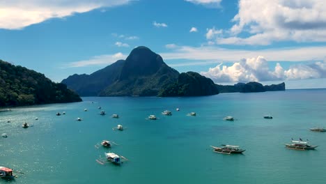 Toma-Aérea-De-Establecimiento-De-Barcos-Atracados-En-La-Bahía-De-El-Nido,-Palawan,-Filipinas