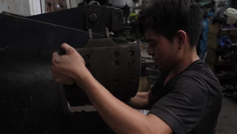 young latin american mechanic repairing and patching heavy truck drum brake pads in mexican workshop