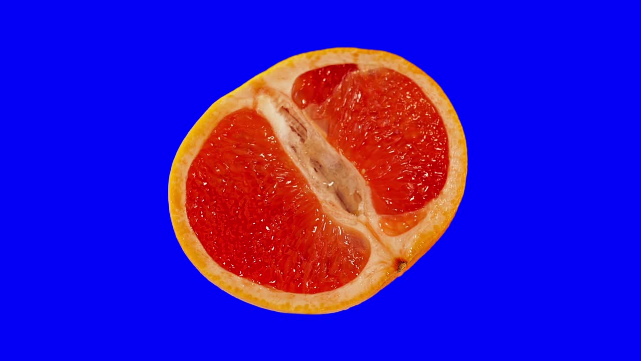 Red grapefruit cut in two on a blue background