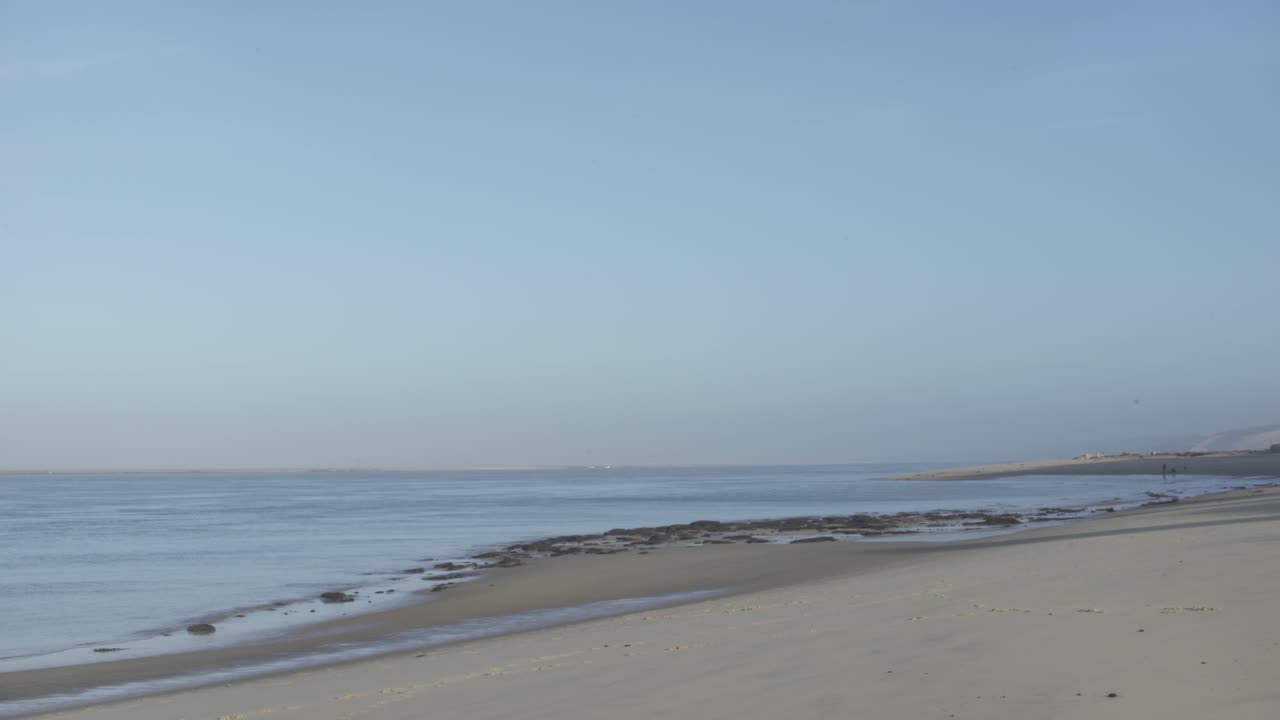 View of the sea and the horizon in winter at dawn. Empty beach with blue sky