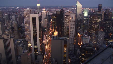 aerial shot zooming out over the new york skyline with lights shining at dusk