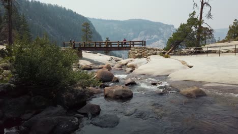 toma estática de un pequeño río con un puente de madera en el fondo