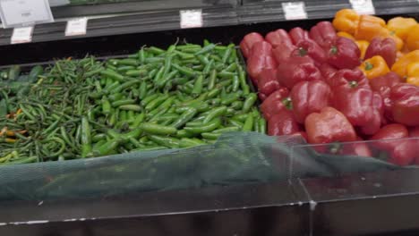 fresh bell peppers in vibrant red, orange, and yellow stacked in a grocery store display