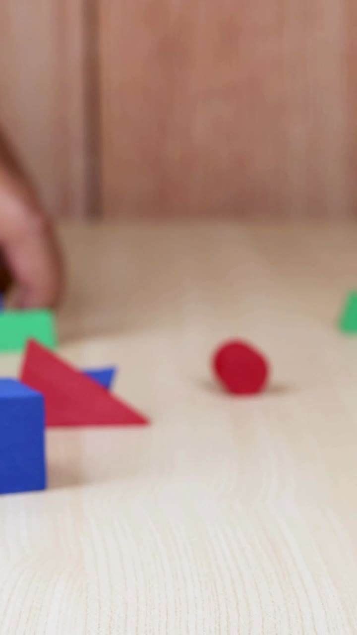 manos arreglando bloques de espuma de colores en la mesa