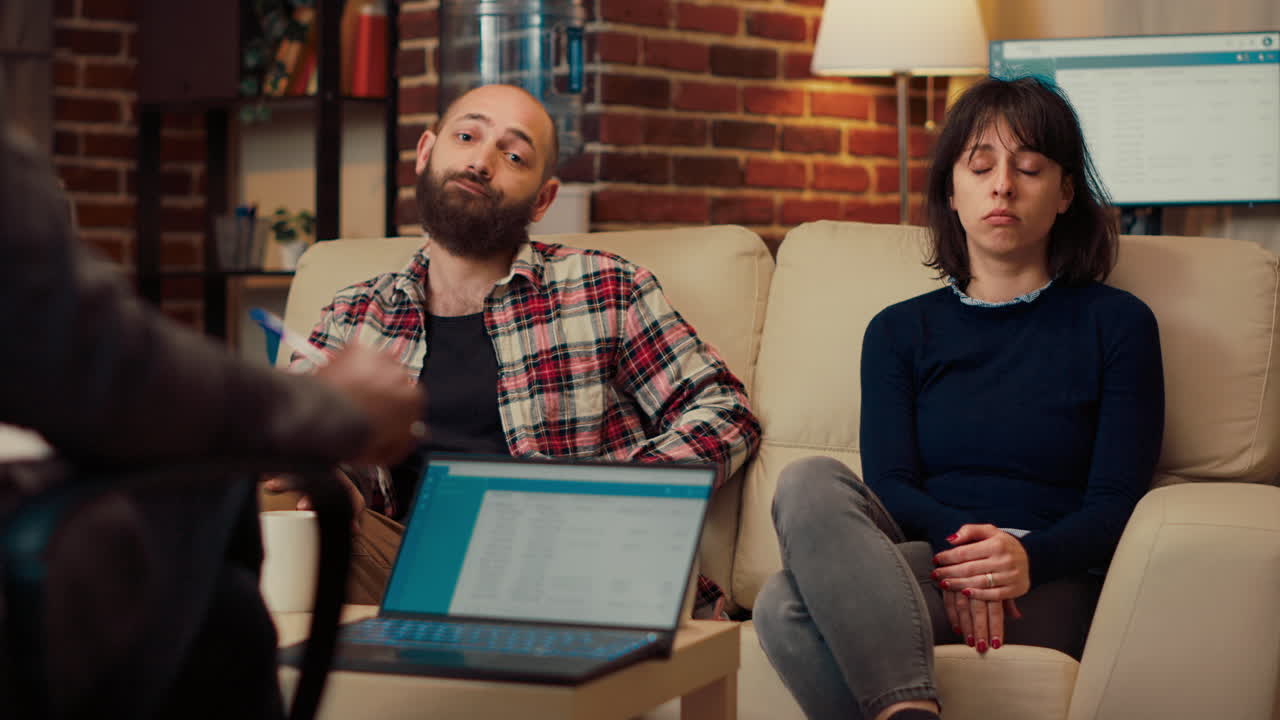 Portrait of unhappy couple attending therapy session with specialist