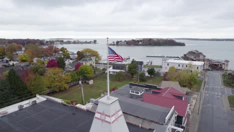 ondea la bandera estadounidense patriótica sobre una pequeña ciudad en estados unidos, pon in bay, ohio