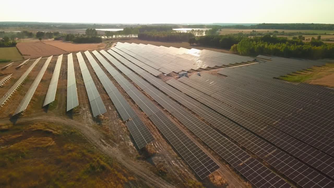 Luftfoto af solcelleanlæg på landet under solskin i de gyldne timer med varmt lys, et koncept for nuludledning og grøn vedvarende energi.
