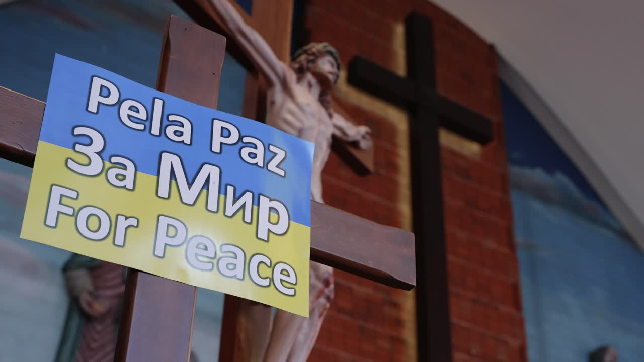 crucifix with a Ukraine-themed peace sign inside a church